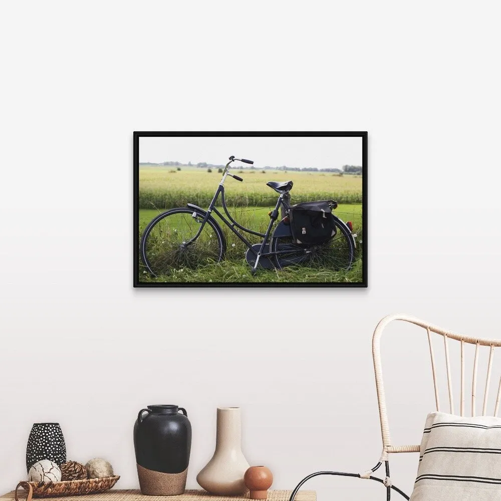 "a bike resting along a fence in the countryside" Black Float Frame Canvas Art